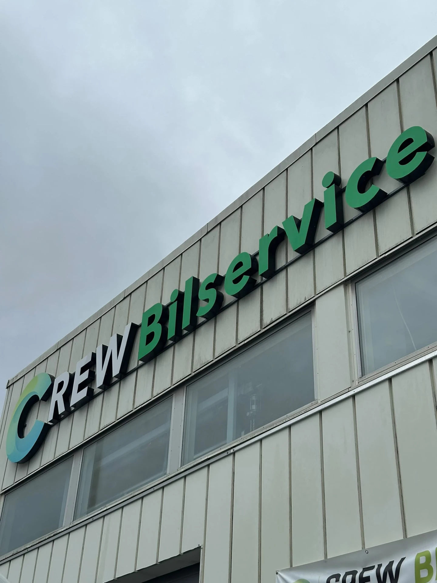 Crew Bilserviceskylten på verkstadens fasad i Sollentuna
